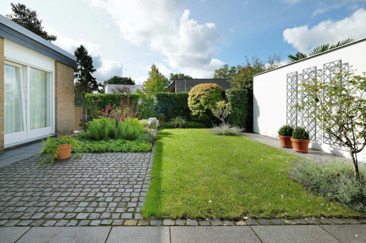 Blick über Terrasse auf das Gartengrundstück vorne