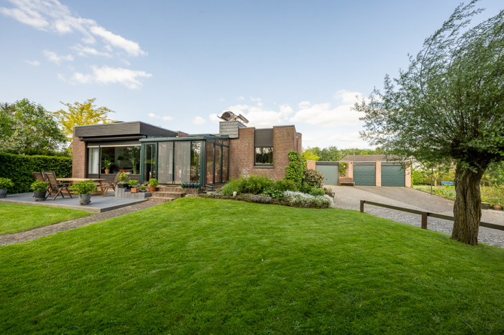 Gartenseite mit Terrasse und Wintergarten