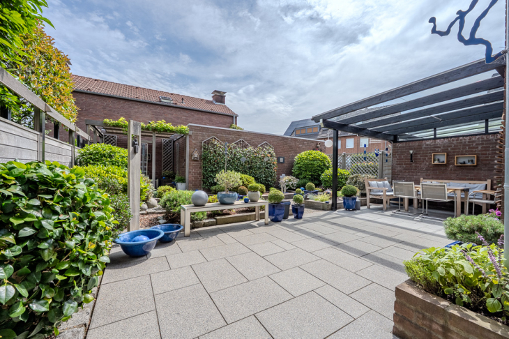 Gepflasterte Terrasse und eingefasste Beete